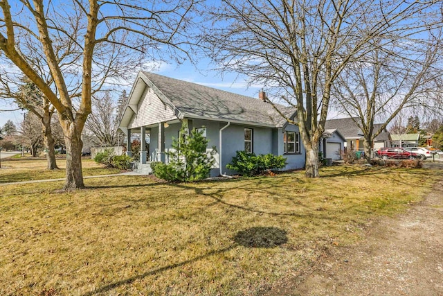 view of side of property featuring a yard, a porch, a chimney, and stucco siding