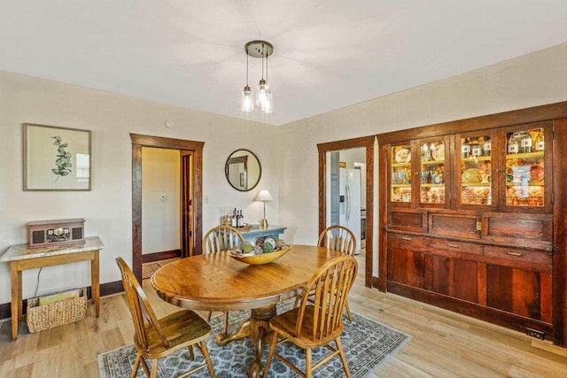 dining room with baseboards and light wood-style floors