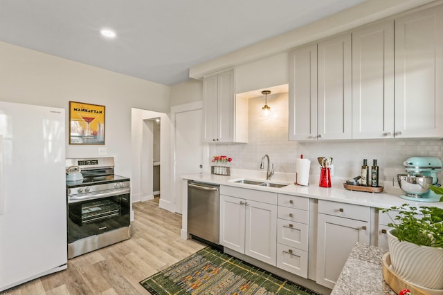 kitchen with a sink, decorative backsplash, appliances with stainless steel finishes, and light countertops