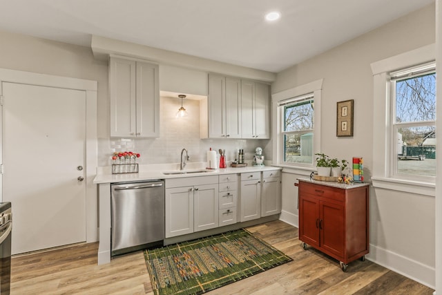 kitchen featuring a sink, stainless steel appliances, light wood-type flooring, and a healthy amount of sunlight