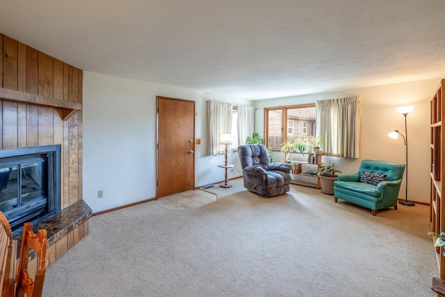 living area featuring a tiled fireplace, carpet, and baseboards