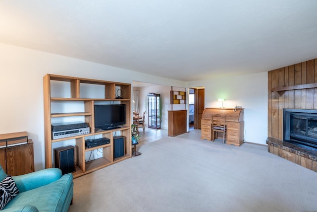 carpeted living area featuring a tiled fireplace