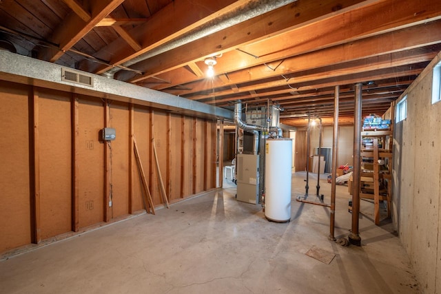 unfinished below grade area with visible vents and gas water heater