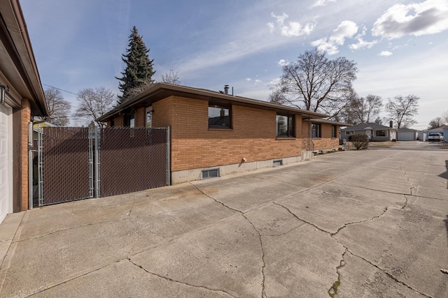 view of home's exterior featuring brick siding and a gate