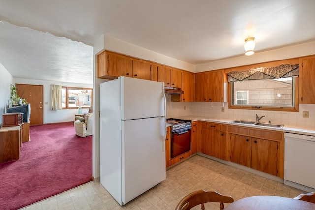 kitchen with white appliances, light countertops, light floors, and a sink