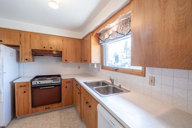 kitchen featuring a sink, white appliances, under cabinet range hood, and light countertops