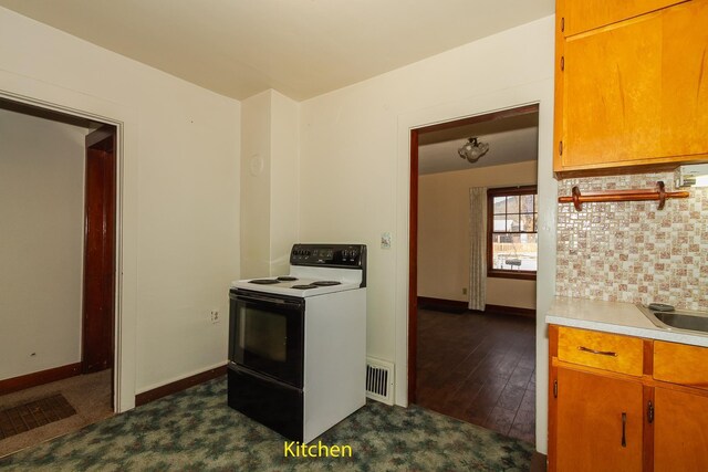460 E Columbia Ave, Colville, WA 99114 - kitchen featuring electric stove, light countertops, baseboards, decorative backsplash, and brown cabinets