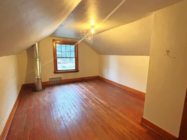 460 E Columbia Ave, Colville, WA 99114 - additional living space featuring hardwood / wood-style floors, a textured ceiling, baseboards, and vaulted ceiling