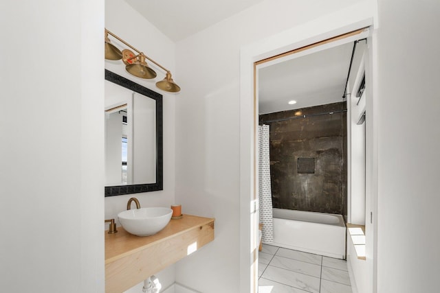 full bath featuring a sink, shower / tub combo with curtain, and marble finish floor