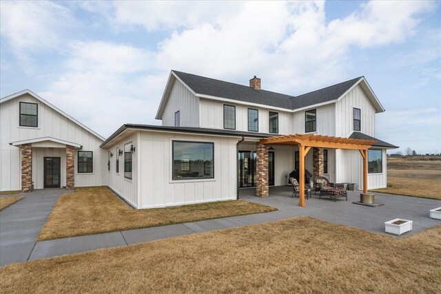 modern farmhouse style home with a pergola, board and batten siding, a front yard, a chimney, and a patio area