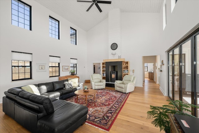 living room with a wealth of natural light, baseboards, light wood-style floors, and wooden ceiling