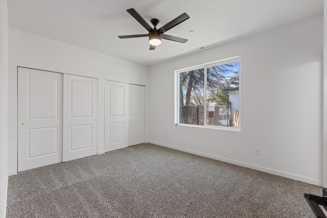 unfurnished bedroom with visible vents, baseboards, ceiling fan, and carpet flooring