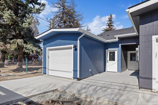 exterior space with fence, a garage, and driveway