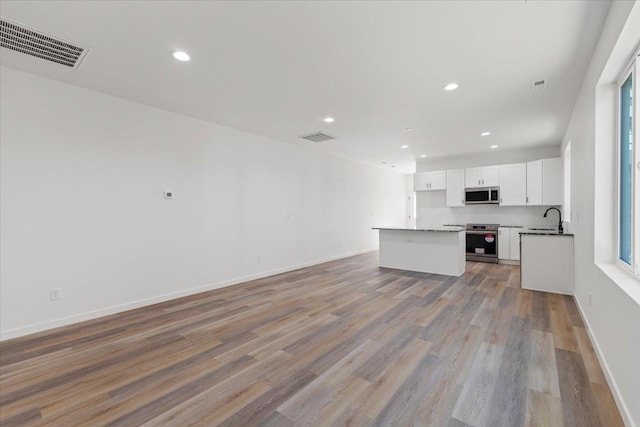 kitchen with visible vents, appliances with stainless steel finishes, open floor plan, and a sink