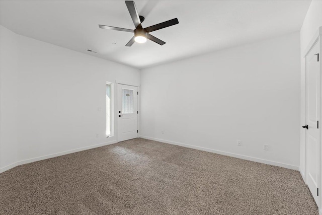 empty room with baseboards, carpet floors, visible vents, and ceiling fan