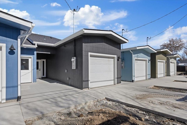 view of side of property featuring concrete driveway and a garage