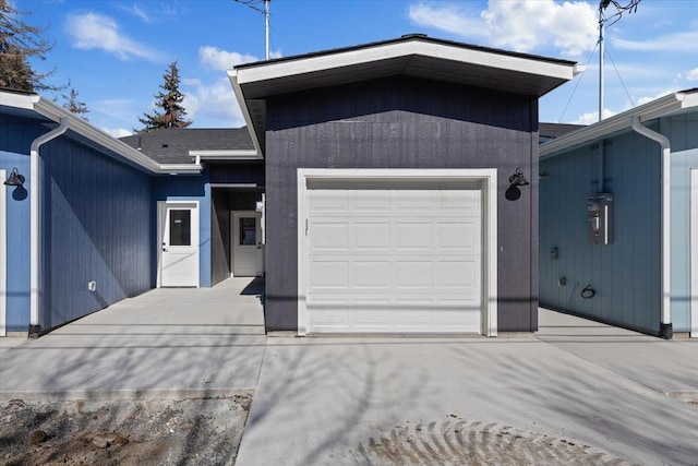 view of front of property with driveway, an attached garage, and a shingled roof