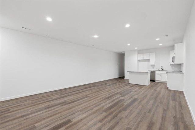 unfurnished living room with recessed lighting, visible vents, baseboards, and wood finished floors