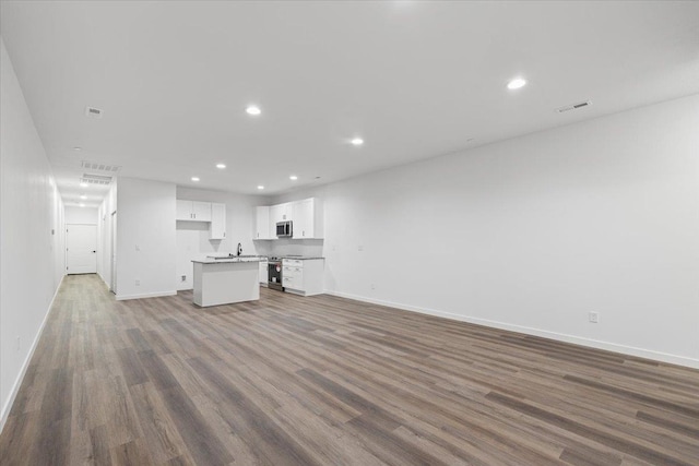 kitchen featuring visible vents, open floor plan, recessed lighting, stainless steel appliances, and white cabinets