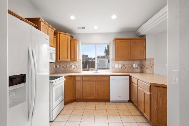 kitchen with visible vents, light countertops, light tile patterned floors, white appliances, and a sink