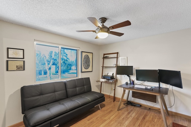 office area featuring ceiling fan, wood finished floors, baseboards, and a textured ceiling