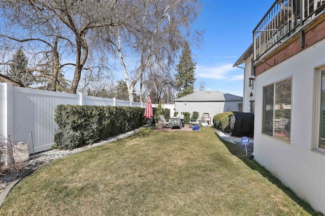 view of yard with a balcony, a fenced backyard, and a patio area