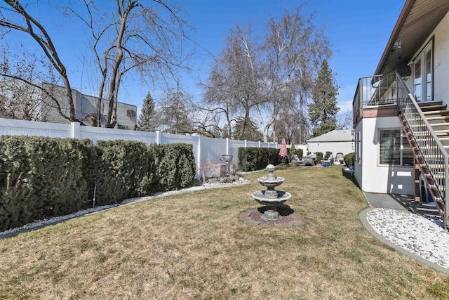 view of yard with stairway and a fenced backyard