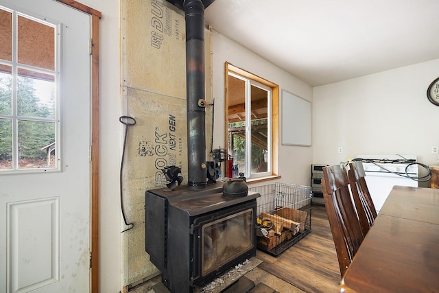 interior space with a wood stove and wood finished floors