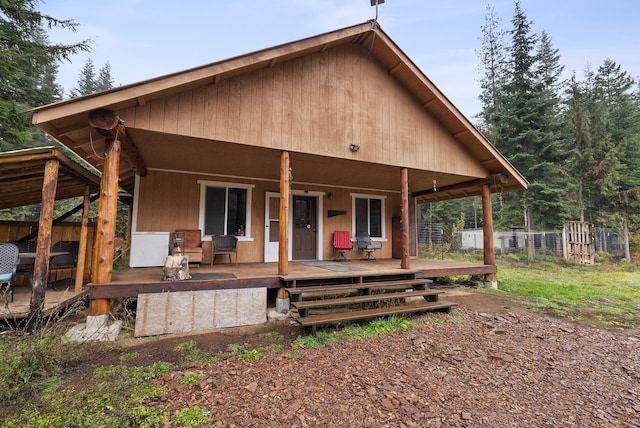 back of house with fence and covered porch