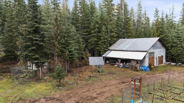 view of outdoor structure featuring an outbuilding and a view of trees