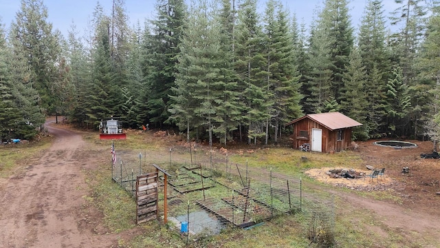 view of yard with a storage shed, an outbuilding, and driveway