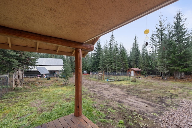 view of yard featuring fence, an outbuilding, and a shed