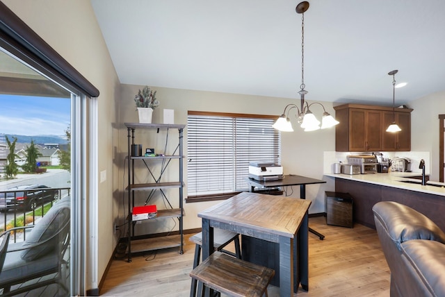 dining space with light wood-style floors, baseboards, and a chandelier