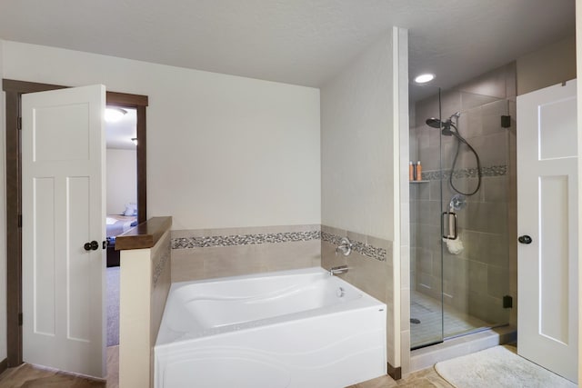 bathroom featuring a garden tub and a shower stall