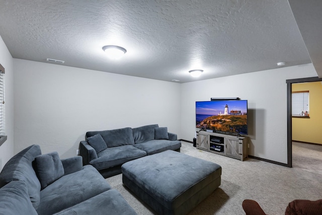 living area featuring visible vents, light carpet, a textured ceiling, and baseboards