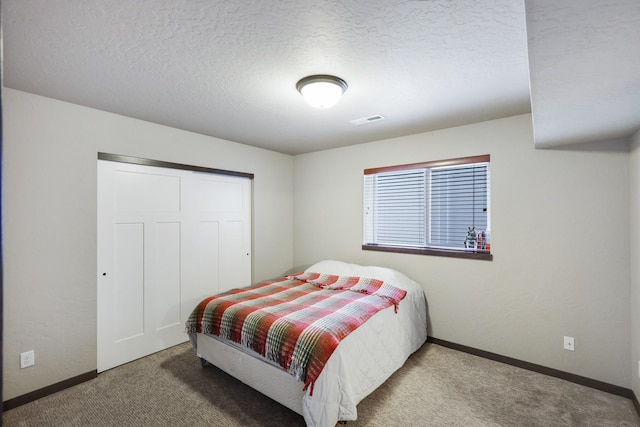 carpeted bedroom with baseboards, visible vents, a closet, and a textured ceiling