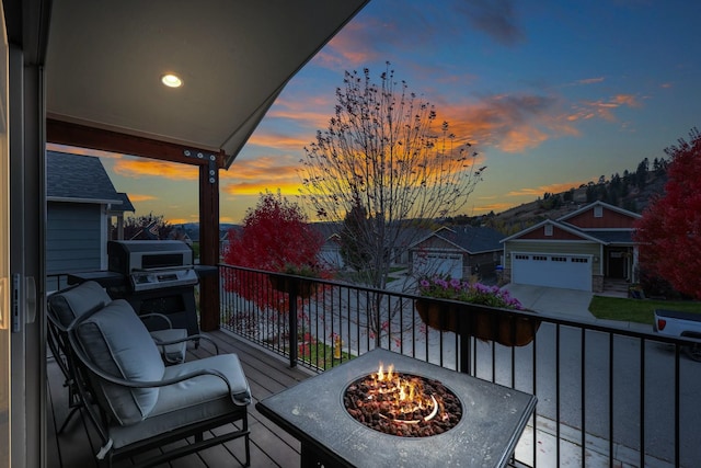 balcony at dusk featuring an outdoor fire pit