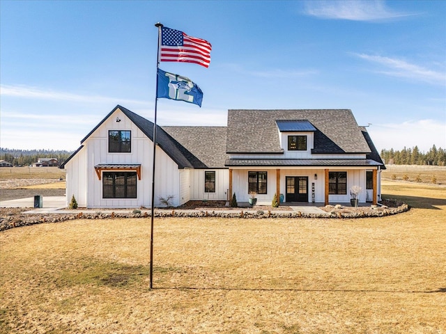 modern inspired farmhouse with roof with shingles, a standing seam roof, a porch, board and batten siding, and metal roof