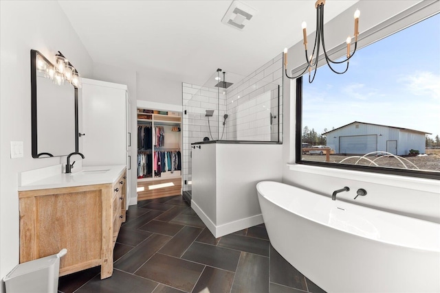 bathroom featuring visible vents, walk in shower, a chandelier, a soaking tub, and vanity