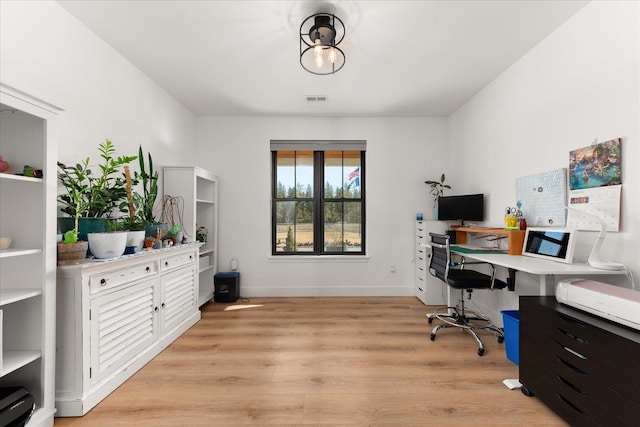 office space featuring light wood-style floors, visible vents, and baseboards