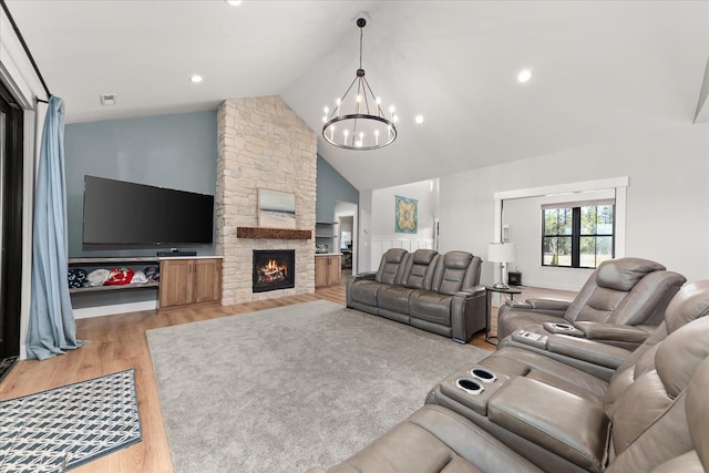 living room featuring high vaulted ceiling, a notable chandelier, recessed lighting, a fireplace, and light wood finished floors