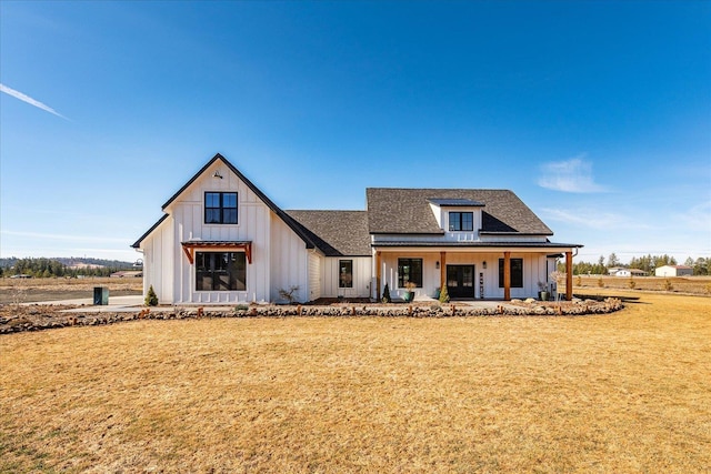 modern inspired farmhouse featuring a front lawn, a porch, board and batten siding, and a shingled roof