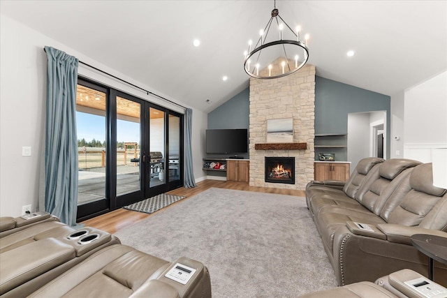 living room with wood finished floors, high vaulted ceiling, a fireplace, recessed lighting, and french doors