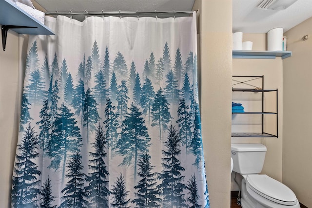 bathroom featuring a shower with curtain and toilet