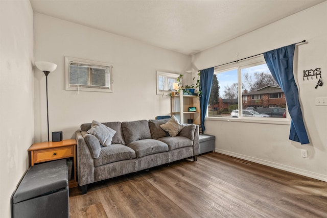 living area featuring visible vents, wood finished floors, and baseboards