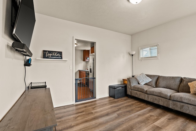 living area with baseboards and wood finished floors