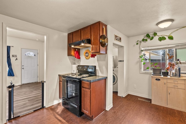 kitchen with under cabinet range hood, dark wood-style flooring, washer / clothes dryer, and black electric range