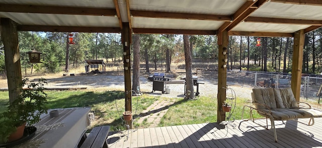 wooden terrace featuring area for grilling, fence, and a lawn