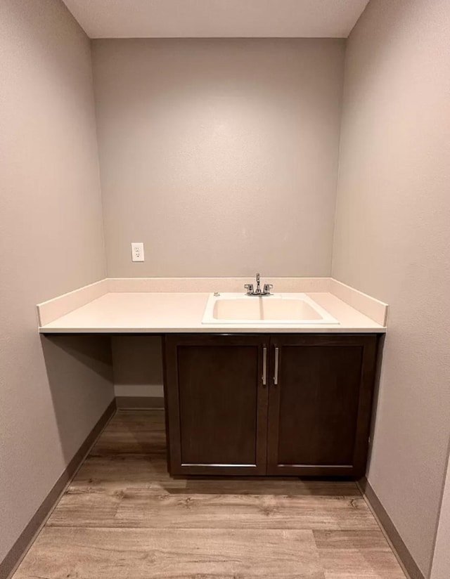 bathroom featuring vanity, wood finished floors, and baseboards