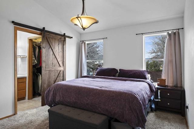 bedroom featuring a barn door, light carpet, lofted ceiling, and a spacious closet